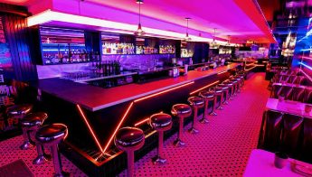 Neon-lit bar counter with stools