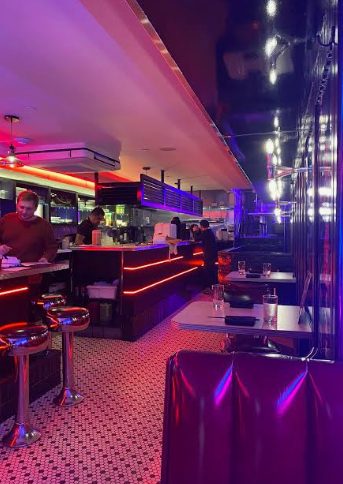 Neon-lit diner interior with counter seating